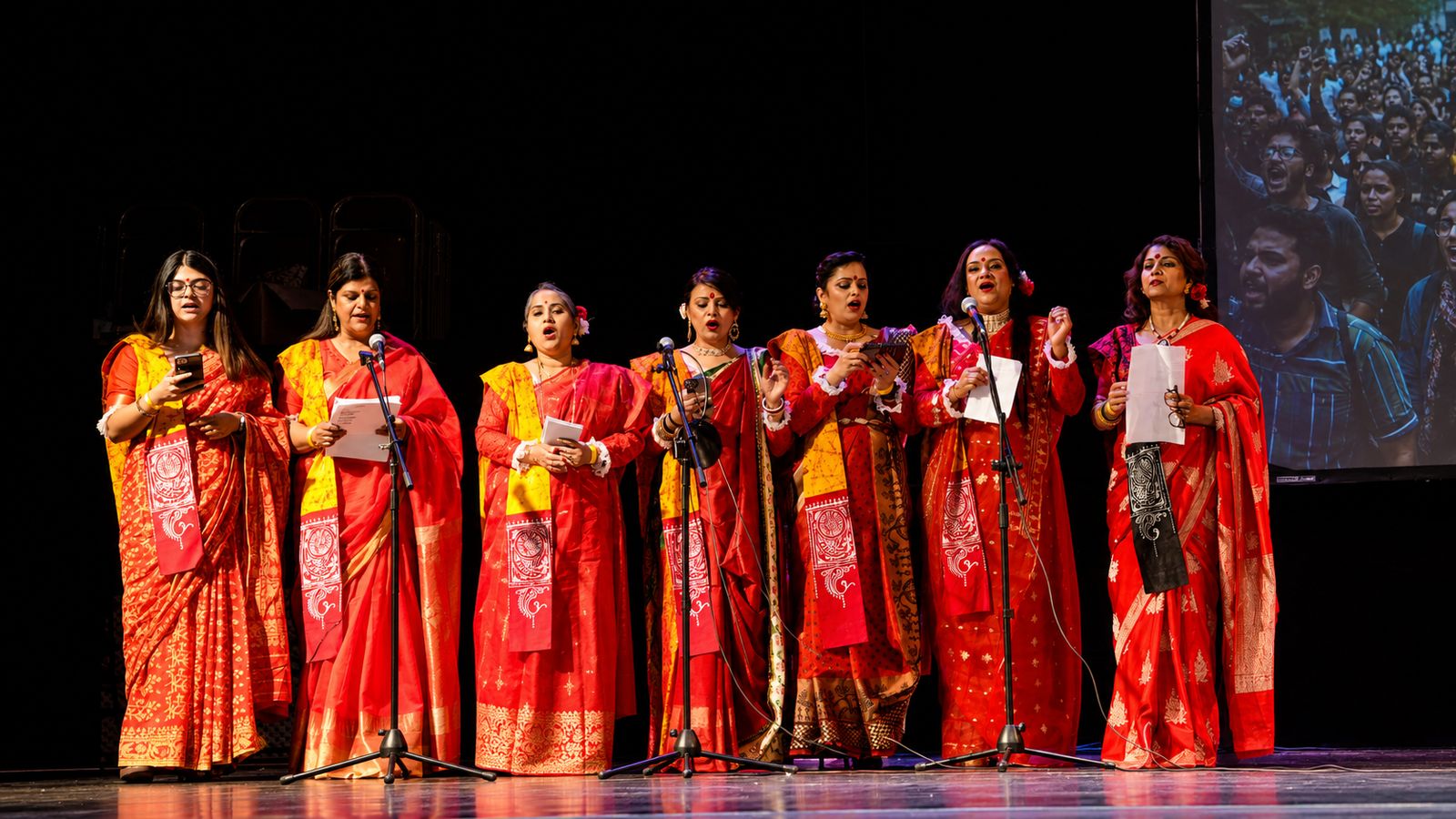 Manchester choir in red and white sarees singing Bengali songs at the Boishakh Festival